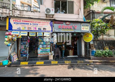 Mumbai, India - 22 novembre 2019: Vista sulla strada di Mumbai durante il giorno di sole con caffè e negozi a Mumbai (conosciuto colloquialmente come Bombay), India. Foto Stock