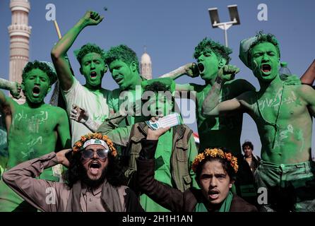 Sanaa, Yemen. 18 Ott 2021. I sostenitori ribelli di Houthi con i loro volti e corpi dipinti prendono parte a una celebrazione che segna l'anniversario della nascita del profeta dell'Islam Muhammad (Mawlid al-Nabi) a Sanaa. Credit: Hani al-ANSI/dpa/Alamy Live News Foto Stock