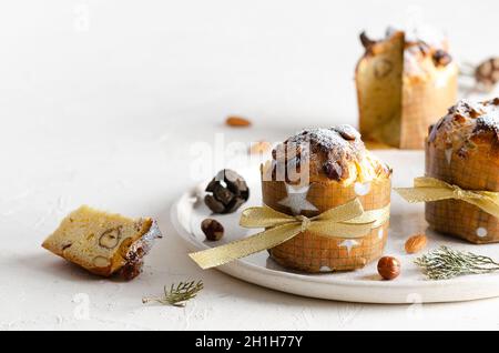 Mini panettone in un piatto bianco su sfondo bianco. Foto Stock