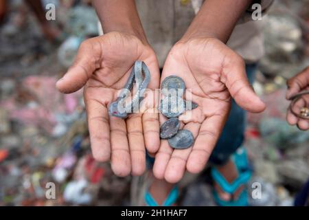 Muradnagar, India. 18 Ott 2021. Un primo piano di mani che mostrano monete di nichel e oggetti di valore trovati dai rifiuti di culto nel canale di Muradnagar. Gli abitanti locali cercano felicemente gli articoli importanti nel canale superiore di Ganges che è accatastato dai torrenti pesanti alle rive del canale. I devoti mentre prendono un tuffo nel canale di Ganga offrono gli oggetti di valore come pratica religiosa o lo perdono inconsapevolmente sopra là. (Foto di Pradeep Gaur/SOPA Images/Sipa USA) Credit: Sipa USA/Alamy Live News Foto Stock