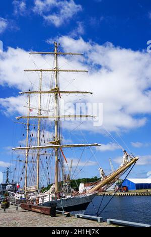 una storica nave a vela con tre alberi al porto ormeggio su sfondo con cielo blu e nuvole bianche Foto Stock