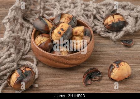 primo piano castagne tostate nella ciotola su tavola di legno Foto Stock