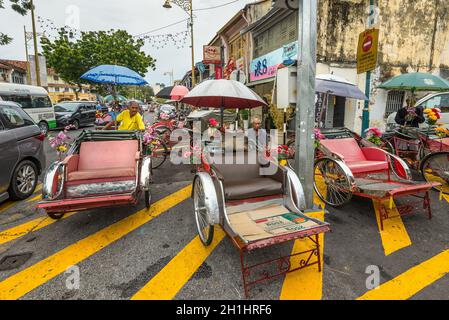 George Town, Penang, Malesia - 1 dicembre 2019: Vita di strada di autisti di Trishaw o rickshaws in George Town, Penang, Malesia in tempo nuvoloso. Io Foto Stock