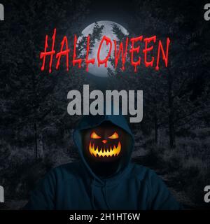 Ritratto di un uomo con una zucca invece di una testa in piedi nella foresta oscura con luce lunare. Horror Halloween concetto. Foto Stock
