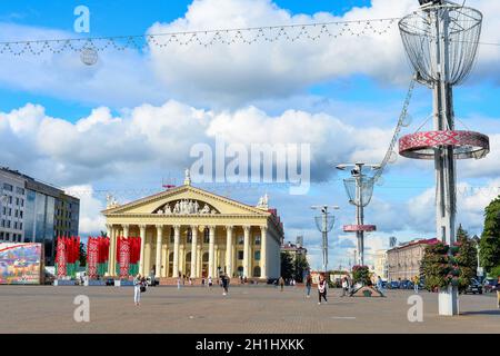 MINSK, BIELORUSSIA - 17 LUGLIO 2019: Persone che camminano nella piazza centrale della città con il Palazzo della Repubblica, paesaggio nuvoloso Foto Stock