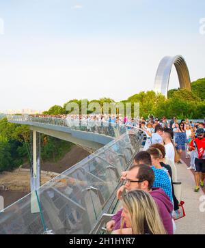 KIEV, UCRAINA - 31 Maggio 2019: folla di persone al nuovo ponte Pedestrian-Bicycle al tramonto. Nuovo Klitschko Pedestrian-Bicycle Bridge uno dei più int Foto Stock