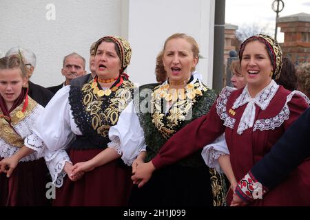 La gente di cantare e ballare dopo la Messa per la Giornata del Ringraziamento in Stitar, Croazia Foto Stock