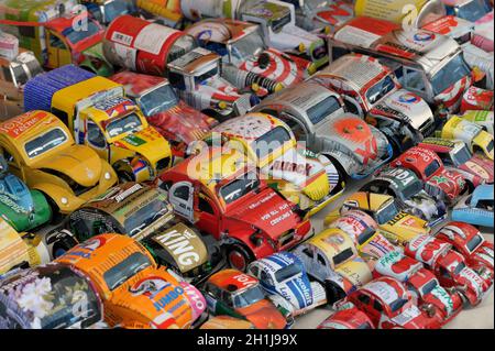Selezione di automobili giocattolo fatte da vecchie lattine di auminium per la vendita su una bancarella. Riciclaggio Foto Stock
