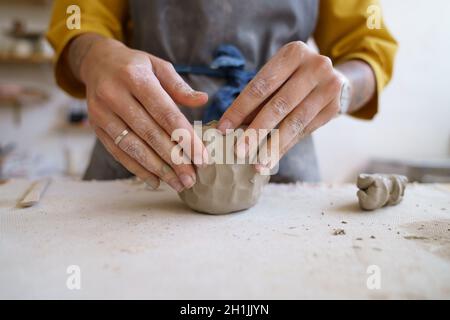 Lavora con le tue mani: Artista femminile stampaggio argilla cruda per la scultura e la modellazione di ceramiche o ceramiche Foto Stock