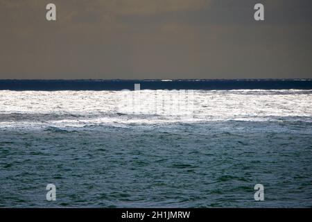 Il canale inglese. Piscine di sole su un mare scintillante. Brighton & Hove, East Sussex, Inghilterra, Regno Unito Foto Stock