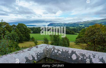 Vista attraverso i giardini verso l'isola di Menia dritto e puffin dal castello di Penrhyn, una casa di campagna normanna a Llandygai, Bangor, Galles del Nord Regno Unito Foto Stock