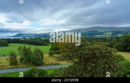 Vista attraverso i giardini verso l'isola di Menia dritto e puffin dal castello di Penrhyn, una casa di campagna normanna a Llandygai, Bangor, Galles del Nord Regno Unito Foto Stock