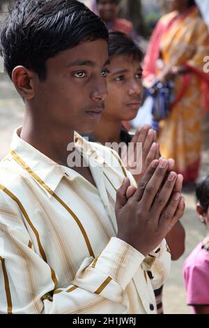 Gruppo di giovani cattolici bengalesi pregano davanti a una statua della Beata Vergine Maria, Bengala Occidentale, India Foto Stock