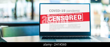 Computer portatile che mostra il segno di censura su Internet sito con covid-19 informazioni pandemiche Foto Stock