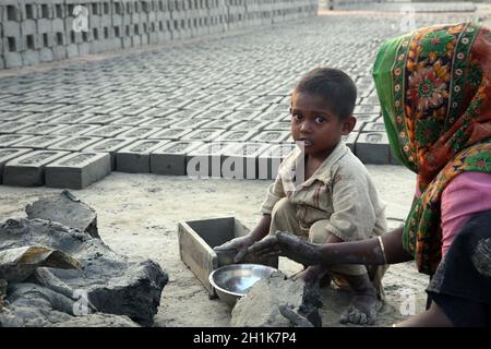 I lavoratori vivono con le loro famiglie all'interno della fabbrica di mattoni, dove lavorano e vivono in condizioni disumane a Sarberia, Bengala Occidentale, India Foto Stock