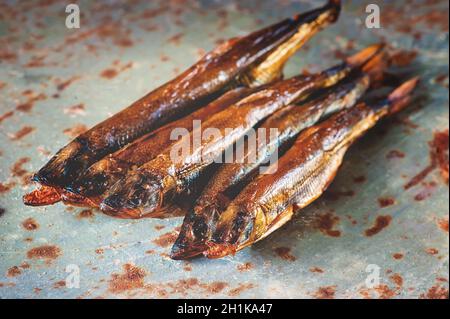 piccolo pesce affumicato. Fresco dorato affumicato si trova su uno sfondo bellissimo. Pesce delizioso e delizioso. Foto Stock