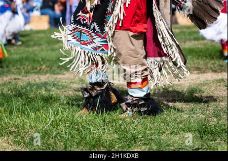 Foto di caviglie e coperta disegnata come parte di una regalia del ballerino dei nativi americani in un evento pubblico di pow wow. Foto Stock