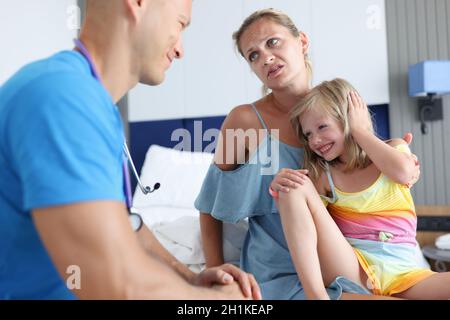 Il medico giovane comunica con la bambina della donna Foto Stock