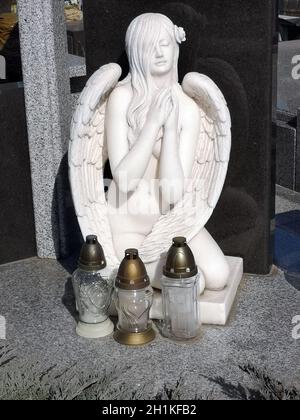 Monumento cimitero in forma di un angelo di bianco di fronte a lei sono tre lomadi 06.04.2020 Kiev Ucraina Foto Stock