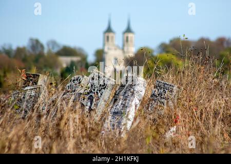 Vecchio cimitero ebraico in autunno. Lapidi su uno sfondo di erba secca in un cimitero. Il cimitero ebraico è un kirkut nel villaggio urbano di S. Foto Stock