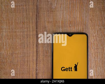 LOD, Israele - 8 luglio 2020: Schermata di lancio dell'app Gett con logo sul display di uno smartphone nero su sfondo in legno. Vista dall'alto piatto con Foto Stock