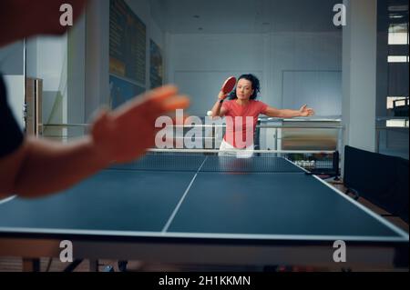 Sportivo uomo e donna, allenamento ping pong, giocatori di ping pong. Coppia che gioca a ping-pong al coperto, gioco sportivo con racket e palla, attivo sano Foto Stock