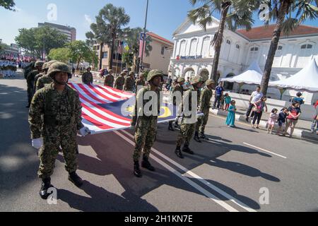 George Town, Penang/Malaysia - 31 2017 agosto: Soldato malese che marciò con la bandiera malese. Foto Stock