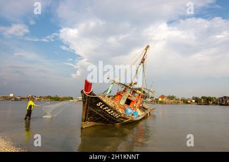 Sekinchan, Selangor/Malaysia - Ott 06 2019: Un pescatore gettò la rete accanto alla barca da pesca. Foto Stock