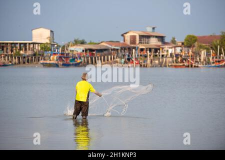 Sekinchan, Selangor/Malaysia - Ott 06 2019: Un pescatore getta la rete. Sfondo è villaggio di pescatori. Foto Stock