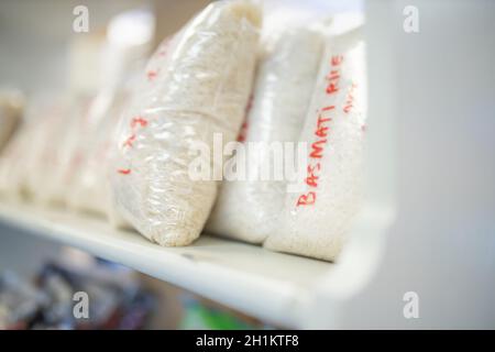 Foto di riso Basmati confezionato in sacchetti di plastica e su una mensola Pronto per la vendita con i prezzi riportati sulle borse Foto Stock