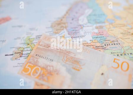 Foto della Svezia su una mappa europea poco nitida con una banconota svedese del 50 -con le parole cinquanta Kronor in svedese- in alto Foto Stock