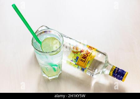 MOSCA, RUSSIA - 4 NOVEMBRE 2020: Vista dall'alto di un bicchiere di highball con gin preparato e cocktail tonico e una bottiglia sdraiata di Gordon's London Dry Gin on ligh Foto Stock