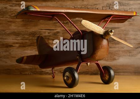 Una vista in primo piano di un aereo giocattolo in legno per bambini appoggiato su una mensola. Foto Stock