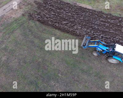 Il trattore arare il giardino. Arare il terreno nel giardino. Foto Stock