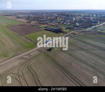 Trattore con sistema articolato di spruzzatura di pesticidi. La concimazione con un trattore, sotto forma di un aerosol, sul campo di grano di inverno Foto Stock