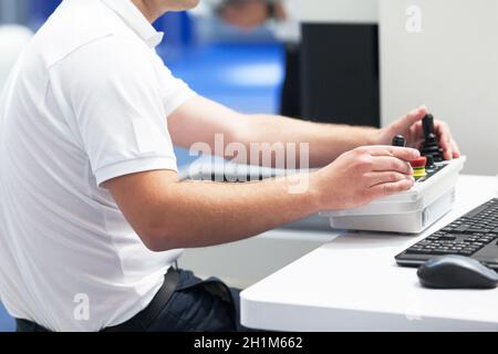 Il tecnico utilizza il joystick per azionare il dispositivo elettronico Foto Stock