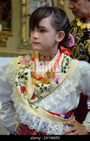 Ragazza vestita in regionali tradizionali costumi folk in chiesa durante la Santa Messa il giorno del Ringraziamento in Stitar, Croazia Foto Stock