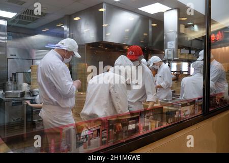 Gli chef preparano il cibo nel ristorante del centro commerciale di Shanghai, Cina Foto Stock