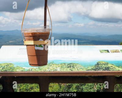 Un bicchiere di tè tailandese su uno sfondo di montagna Parco Nazionale di Khao Yai Foto Stock