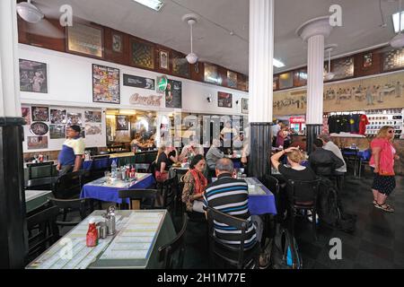Clienti del popolare ristorante vecchio stile il Leopold Cafe Colaba a Mumbai, India Foto Stock