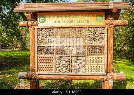 Casa di insetti per insetti e api in legno, mattoni, coni e paglia nello Zoo di Kiev Foto Stock