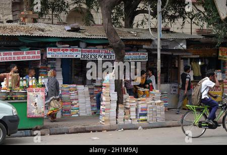 Gli studenti check out libri a una vecchia strada laterale prenota stallo a College Street del mercato del libro in Kolkata, India Foto Stock