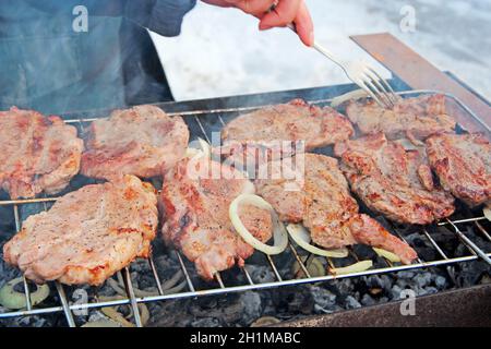 Pezzi di carne con cipolle sono cucinati al barbecue. Pezzi di cipolla e bistecca cotti al fuoco. Grigliate al fuoco. Processo di cottura della carne. Cucina Foto Stock