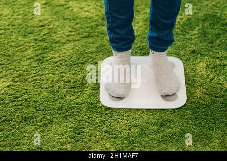 Bilance intelligenti per la casa. La ragazza misura il peso durante la dieta. Foto Stock