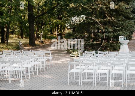 area per cerimonie nuziali con arco circolare decorato con fiori Foto Stock