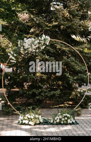 area per cerimonie nuziali con arco circolare decorato con fiori Foto Stock