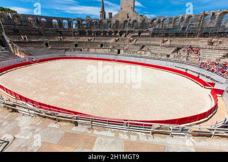 Arles, Francia - 19 GIUGNO - 2018: Un gruppo di turisti che riposano sui gradini dell'antico anfiteatro. Foto Stock