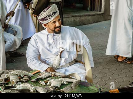 Nizwa, Oman, 2 dicembre 2016: Un fornitore sta vendendo khanjars - i pugnali tradizionali di Omani - al mercato della pistola di venerdì a Nizwa Foto Stock