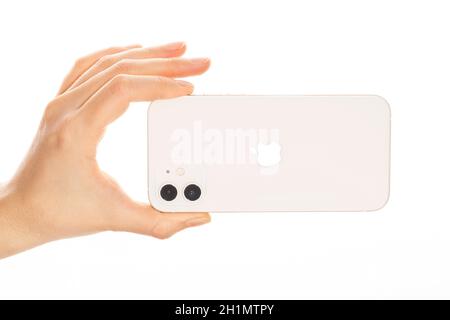 Bratislava, Slovacchia - 07 dicembre 2020. Mano femminile che tiene il nuovo iPhone 12 bianco. Foto Stock