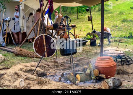 Cedynia, Polonia, giugno 2019 rievocazione storica del campo tenda della tribù Slavica o Vichinghi con focalizzazione selettiva sul fuoco del campo, che mostra la vita dei contadini Foto Stock